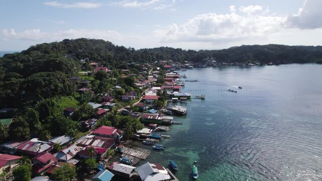 Aerial - Bastimentos Island with coastal homes and lush green hills, Panama