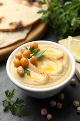 Delicious hummus with olive oil and chickpeas served on grey table