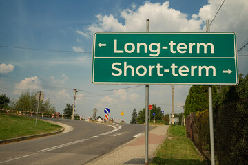 Tablica informacyjna przy drodze Long-term, Short-term w słoneczny dzień.