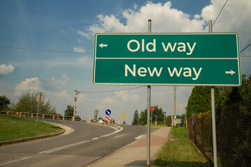 drogowskaz przy drodze z z napisem Old way, New way w słoneczny letni dzień. © siwyk