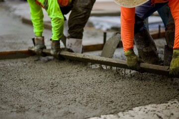 road crew spreading wet concrete in the road