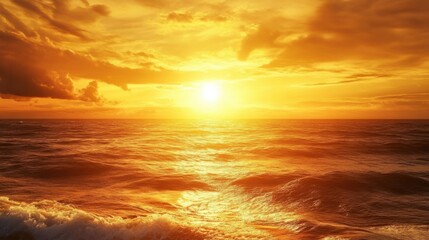 Obraz premium A golden yellow sunset over the ocean, casting light across the waves and horizon.