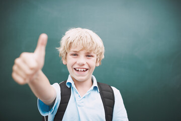 Portrait, happy kid and thumbs up by chalkboard for learning, quality education and success. Face, school child and boy with like hand gesture for agreement, yes and student recommend scholarship