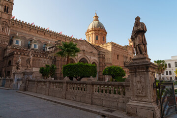 Obraz premium Wide view of Palermo Cathedral in Sicily, showcasing its impressive dome, detailed facade, and the lively plaza in front during a sunny day
