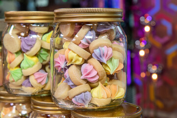 A jar of delicious sweet cookie biscuits in the shape of iced gems