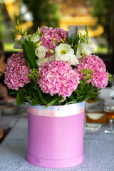 Beautiful blooming bouquet of fresh pink hydrangeas stands on the table