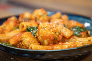 A delicious plate of pasta and meatballs on a wooden background