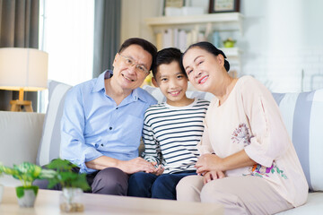 Obraz premium Asian family with father, mother, and son staying in living room together.