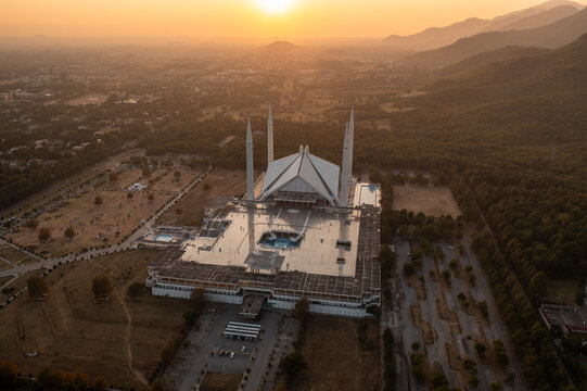 Aerial view of faisal masjid mosque at sunset with majestic mountains and serene cityscape, islamabad, pakistan.