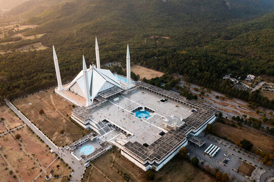 Aerial view of faisal masjid mosque surrounded by majestic mountains and greenery, islamabad, pakistan.