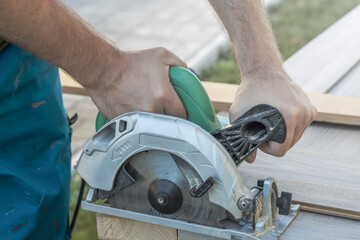 A man is using a power tool to cut wood