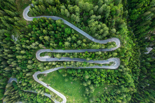 Aerial view of winding mountain road through lush forest and trees, Kranjska Gora, Slovenia.