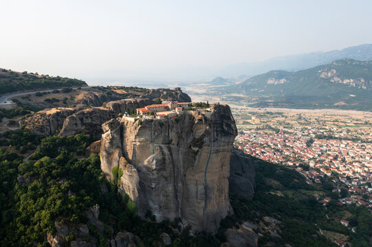Aerial view of ancient monasteries atop stunning rock formations in a scenic valley, Kalabaka, Greece.