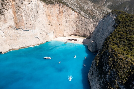 Aerial view of navagio beach with turquoise water and a shipwreck surrounded by cliffs, Volimes, Greece.