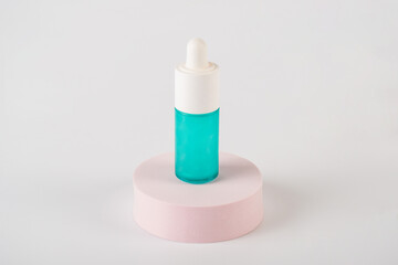Blue glass cosmetic bottle, Skin care or sunscreen cosmetic with stylish props on white background.