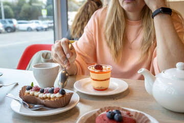 A woman is eating a dessert with a spoon