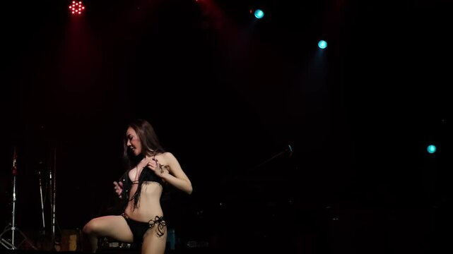 Asian women dancing sexy dance moves and body shapes on stage with lights at night.