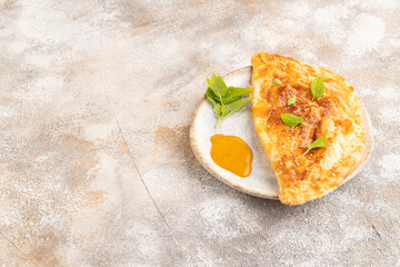 Fried homemade khachapuri cake with cheese and meat, fried in pan. Side view, copy space.