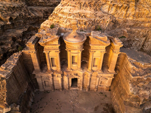 Aerial view of the majestic ancient monastery carved into sandstone cliffs amidst scenic rock formations, lw lbtr, Jordan.