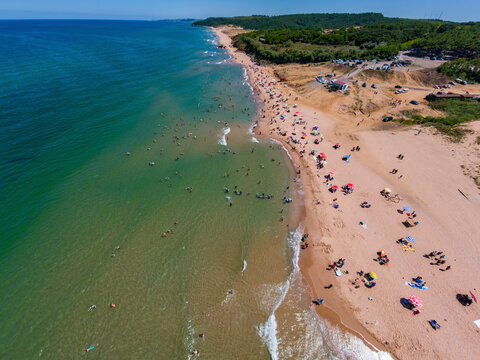 Aerial view of a beautiful sandy beach with umbrellas and people enjoying the calm Black Sea, Sahilkoy, Sile, Turkey.