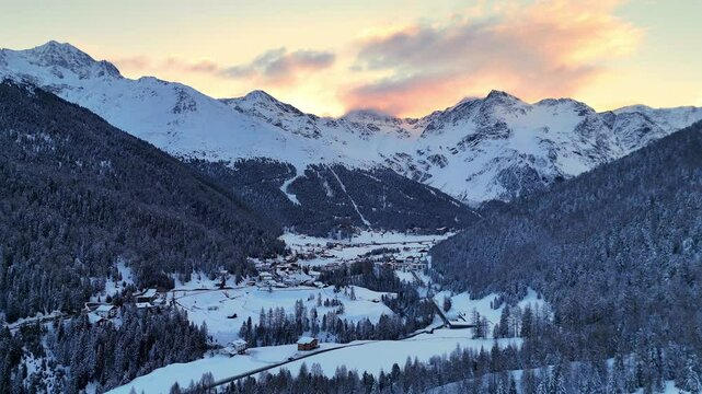 Aerial drone shot of the wintry Sulden valley in the European Alps at sunrise