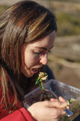 Close-up view of young woman eating salad in nature after hiking.