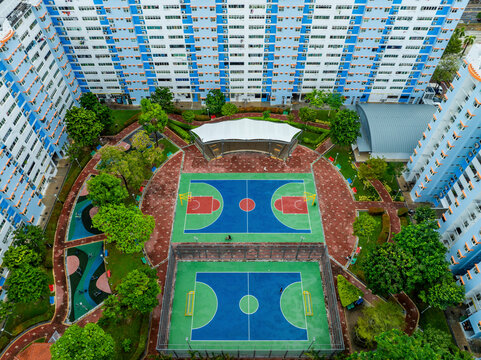 Aerial view of a beautiful urban landscape featuring public housing, soccer and basketball courts, and greenery in Kallang, Singapore.