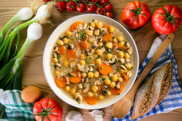 Chickpea and rice soup with mushrooms and vegetables. Top view table with  decorations.