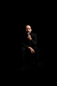 Man contemplating in a dark room, a somber mood
