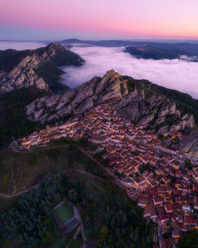 Aerial view of picturesque town with traditional architecture and a soccer field at sunrise, Pietrapertosa, Italy.