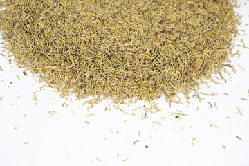 Pile of dried rosemary seasoning on a white background close-up.