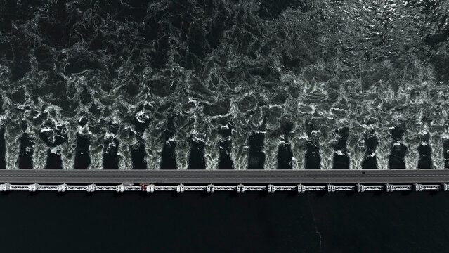 Aerial view of Oosterscheldekering storm surge barrier with waves crashing in the North Sea, Vrouwenpolder, Netherlands.