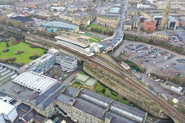 Fototapeta premium Aerial drone photo of the town centre of the town of Halifax in West Yorkshire showing the old historic buildings and train station on a foggy day in the winter time
