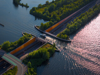 Aerial view of the beautiful aquaduct over Veluwemeer with boats and traffic on the highway, Harderwijk, Netherlands.