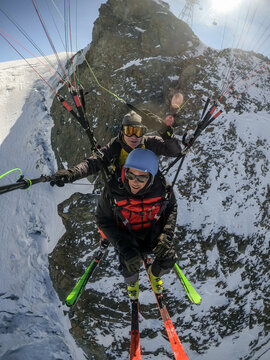 Tandem paragliding over snowy mountain peaks