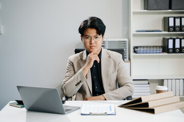 Young business man working at office with laptop, tablet and taking notes on the paper..