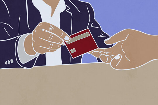 Hand giving red credit card to another at desk
