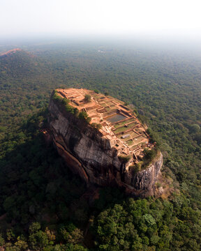 Aerial view of the ancient lion rock fortress surrounded by lush greenery and forest, Sigiriya, Sri Lanka.