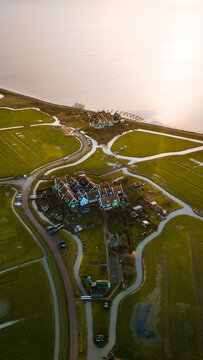 Aerial view of a picturesque village with traditional houses by a serene lake at sunrise, Marken, North-Holland, Netherlands.
