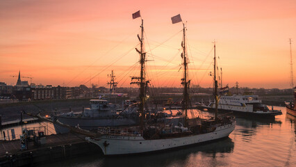 Harlingen, Netherlands - 25 February 2021: Aerial view of the tranquil port with the tall ship Bark Europa at sunrise, Harlingen, Netherlands.