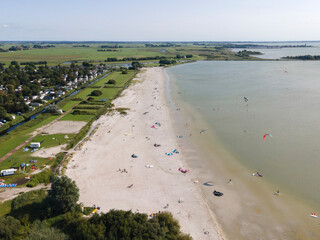 Aerial view of a beautiful beach with kite surfers and campers near the IJsselmeer, Workum, Netherlands.