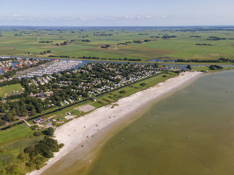 Aerial view of a picturesque beach with kite surfing and a tranquil campsite by the ijsselmeer, Workum, Netherlands.