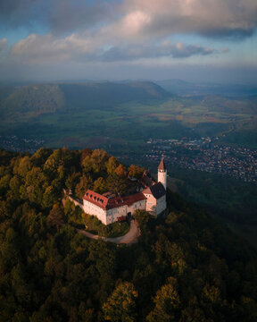 Aerial view of a beautiful castle on a mountain surrounded by forests and valleys at sunrise, Burg Teck, Baden-Wurttemberg, Germany.