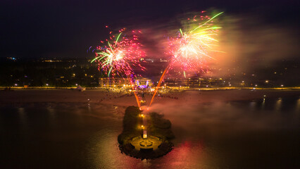Aerial view of colorful fireworks over a beach and pier at night, Makkum, Netherlands.