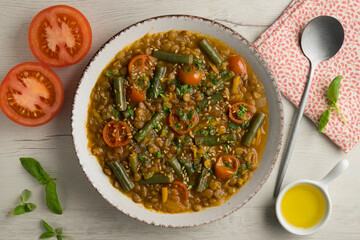 Lentil soup with green beans and cherry tomatoes. Top view table with  decoration.