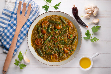 Lentil soup with green beans and cherry tomatoes. Top view table with  decoration.