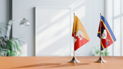 FLAGS OF BHUTAN AND ESWATINI ON TABLE