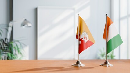 FLAGS OF BHUTAN AND IVORY COAST ON TABLE