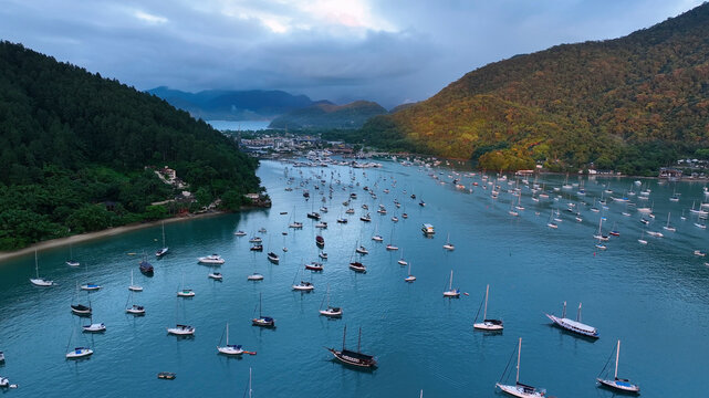 Aerial view of serene harbor with anchored yachts and lush mountains, Angra dos Reis, Brazil.