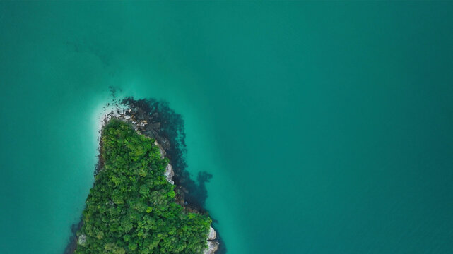Aerial view of a lush tropical island surrounded by serene blue ocean, Paraty, Brazil.